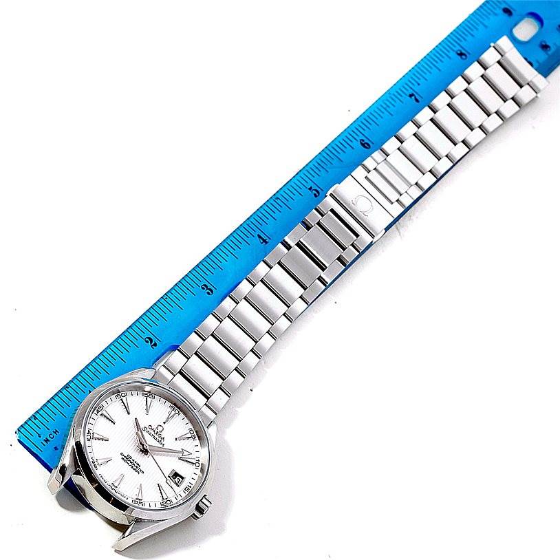 The Omega Aqua Terra 231.10.42.21.02.001 Men
s Stainless Steel Silver Dial 231.10.42.21.02.001 Men
s Stainless Steel Silver Dial watch shown is fully extended with a blue ruler positioned along its bracelet for measurement.