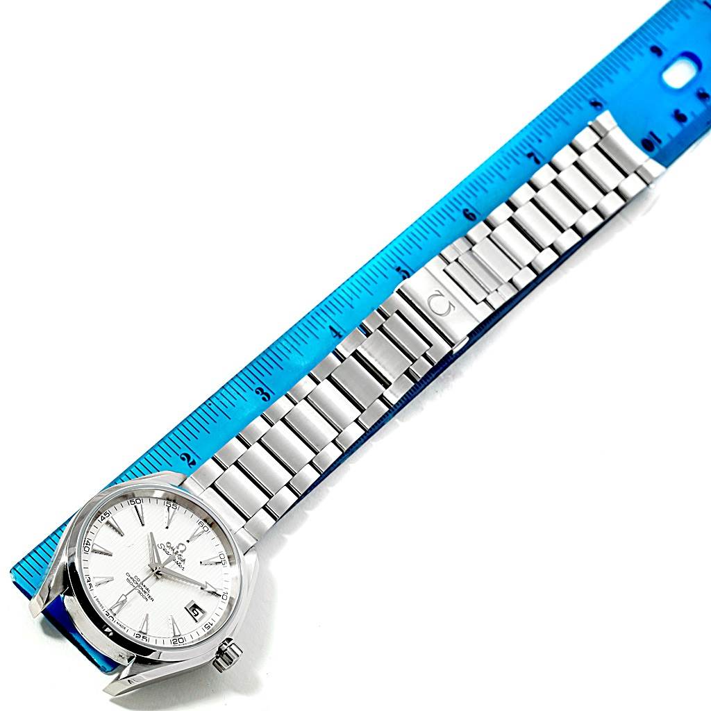 The image shows the Omega Aqua Terra 231.10.42.21.02.001 Men
s Stainless Steel Silver Dial 231.10.42.21.02.001 Men
s Stainless Steel Silver Dial watch from a top-down angle, displaying its face and metal bracelet alongside a blue ruler.