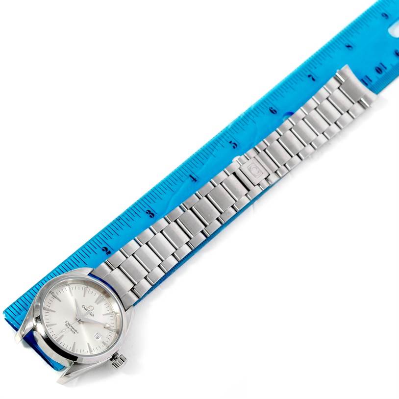 The image shows an Omega Aqua Terra 2518.30.00 Men
s Stainless Steel Silver Dial 2518.30.00 Men
s Stainless Steel Silver Dial watch laid flat beside a ruler, displaying its face, bracelet, and clasp.