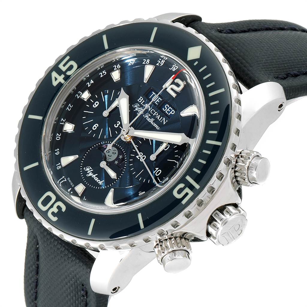 The Fifty Fathoms Blancpain watch is shown at a three-quarter angle, highlighting the bezel, dial, and side chronograph pushers.