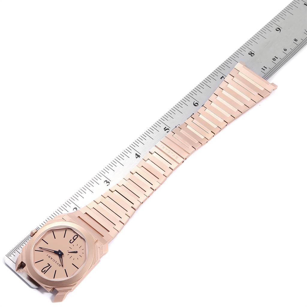 The Bvlgari Octo 102912 Men
s Rose Gold Pink Dial 102912 Men
s Rose Gold Pink Dial watch is shown from a top-down angle with its strap extended alongside a ruler for scale.