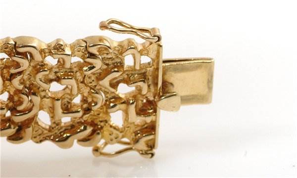 This image shows a detailed close-up of the band clasp of a Rolex Cocktail 2604 Women's Yellow Gold Champagne Dial 2604 Women's Yellow Gold Champagne Dial model watch, highlighting its intricate gold design.