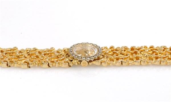 The image shows a side view of the Rolex Cocktail 2604 Women's Yellow Gold Champagne Dial 2604 Women's Yellow Gold Champagne Dial model watch, highlighting its gold bracelet and diamond-studded bezel.