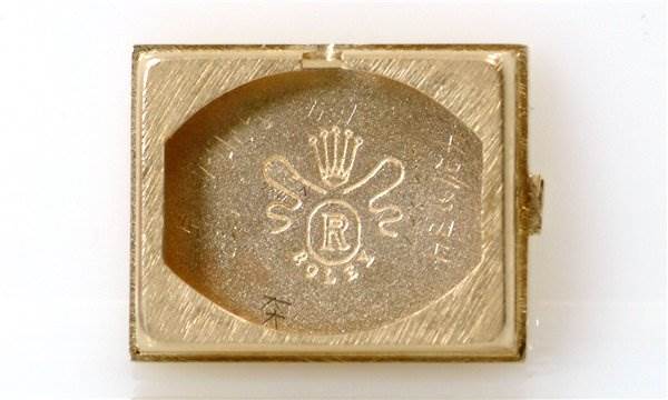 This image shows the back inner case of a Rolex Cocktail Women's Yellow Gold Black Dial Women's Yellow Gold Black Dial model watch, highlighting the brand's emblem and design.