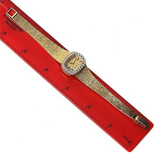 The image shows a Rolex Cocktail 8365 Women's Yellow Gold Champagne Dial 8365 Women's Yellow Gold Champagne Dial watch laid flat next to a red ruler, displaying the entire watch from strap to face.
