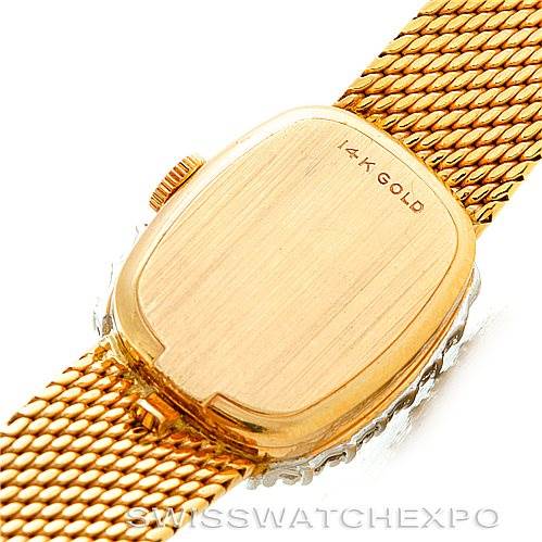 The image shows the back case and part of the gold bracelet of the Rolex Cocktail Women's Yellow Gold Silver Dial Women's Yellow Gold Silver Dial watch, highlighting the 14K gold marking.