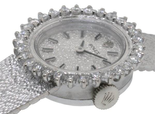This image shows a close-up of the Rolex Cocktail 8032 Women's White Gold Silver Dial 8032 Women's White Gold Silver Dial model watch from an angle highlighting the face and bejeweled bezel.