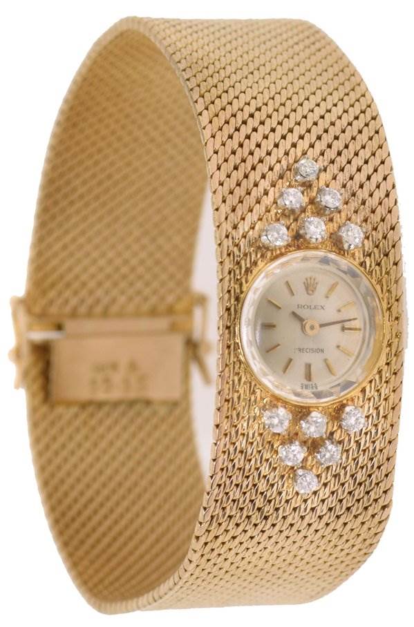 The Rolex Cocktail 2604 Women's Yellow Gold Silver Dial 2604 Women's Yellow Gold Silver Dial model watch is shown from a three-quarter angle, highlighting its diamond embellishments, bracelet, and dial.