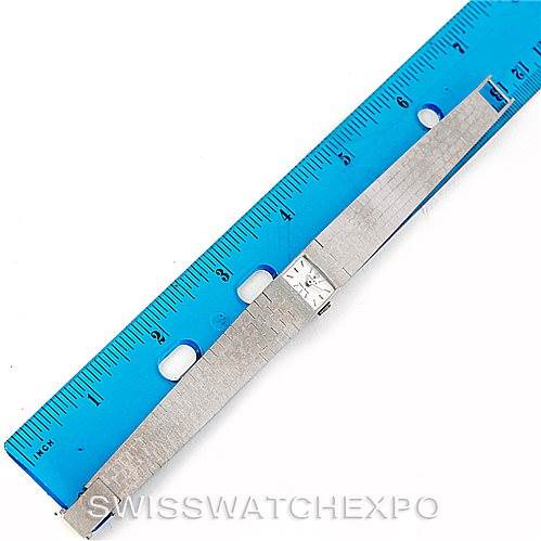 The image shows a Rolex Cocktail 2159 Women's White Gold Silver Dial 2159 Women's White Gold Silver Dial model watch laid flat next to a blue ruler, highlighting its strap and small face.