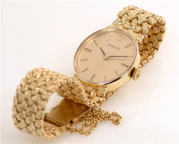 The Rolex Cocktail Women's Yellow Gold Champagne Dial Women's Yellow Gold Champagne Dial model watch is shown from an angled side view, displaying its gold mesh bracelet and clasp.