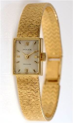 This image shows a side angle of the Rolex Cocktail 173J Women's Yellow Gold Silver Dial 173J Women's Yellow Gold Silver Dial model, prominently featuring its gold rectangular dial and matching textured bracelet.