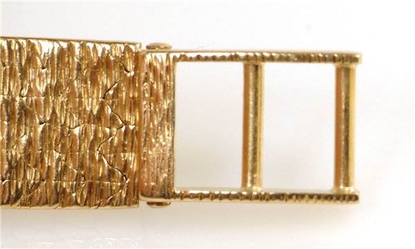 This image shows the clasp and part of the textured bracelet of the Rolex Cocktail 173J Women's Yellow Gold Silver Dial 173J Women's Yellow Gold Silver Dial model watch from a close-up angle.