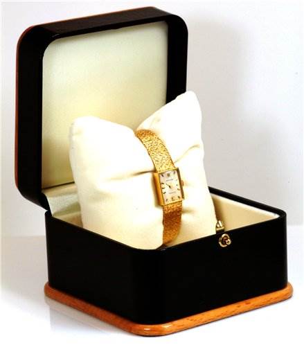 The Rolex Cocktail 173J Women's Yellow Gold Silver Dial 173J Women's Yellow Gold Silver Dial model watch is displayed in an open watch box at an angle showing )the face and band.