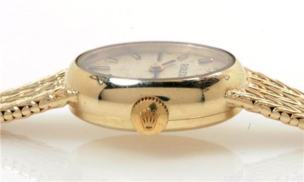 The image shows a side angle of a Rolex Cocktail 8415 Women's Yellow Gold Champagne Dial 8415 Women's Yellow Gold Champagne Dial watch, highlighting the crown and detailed gold bracelet.
