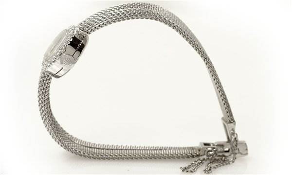 The Rolex Cocktail Women's White Gold Silver Dial Women's White Gold Silver Dial model watch is shown from a side angle, highlighting its mesh bracelet and clasp.