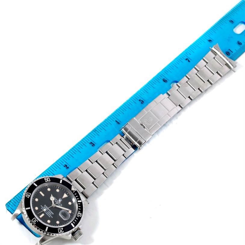 The image shows a top-down view of a Rolex Vintage Collection 168000 Men's Stainless Steel Black Dial 168000 Men's Stainless Steel Black Dial watch, highlighting the dial, bezel, and bracelet next to a ruler.