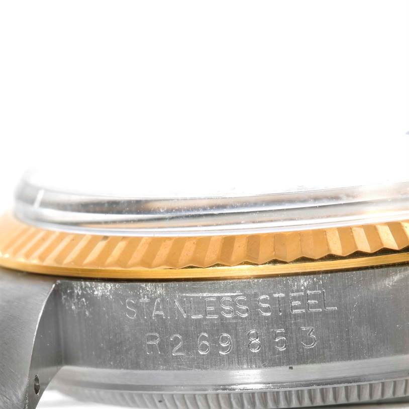 The image shows a close-up of the case side and bezel of the Vintage Collection Rolex, highlighting the stainless steel material and engraved serial number.