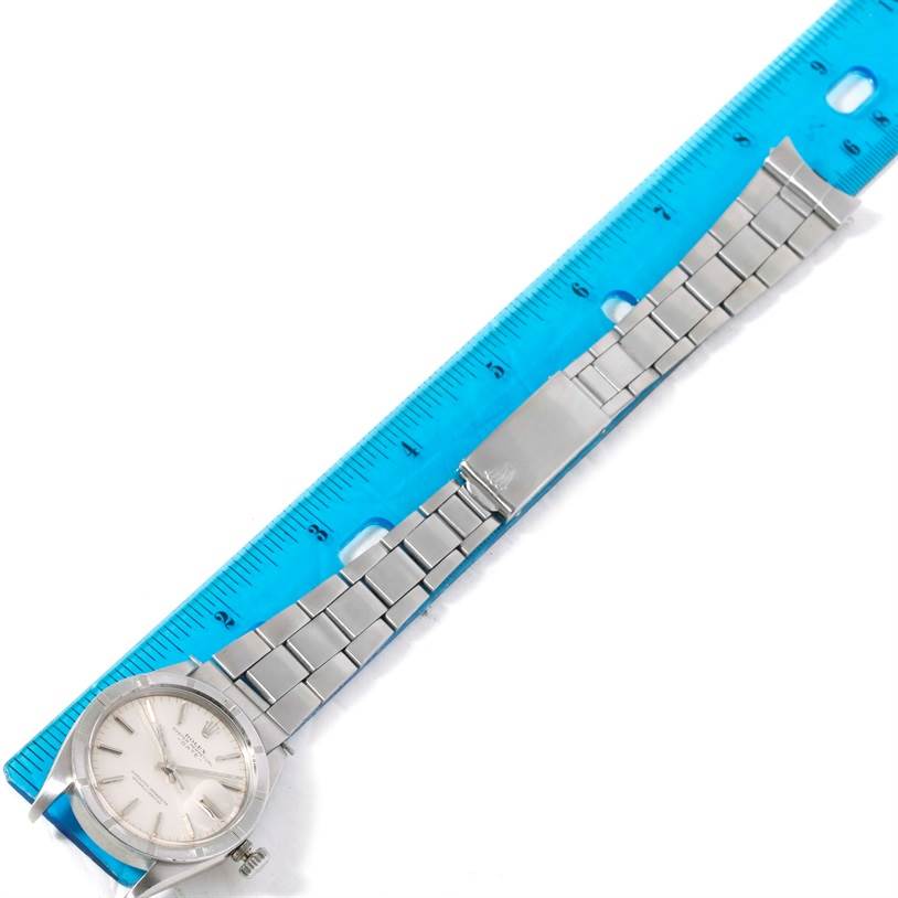 The Rolex Vintage Collection 1501 Men's Stainless Steel Silver Dial 1501 Men's Stainless Steel Silver Dial watch is shown from a top-down angle, displaying the face, bracelet, and clasp alongside a ruler.