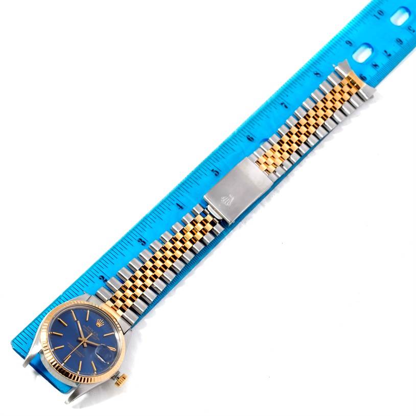 The image shows a Rolex Vintage Collection 16013 Men's Stainless Steel Blue Dial 16013 Men's Stainless Steel Blue Dial watch angled horizontally, including its gold and silver bracelet alongside a blue ruler for scale.