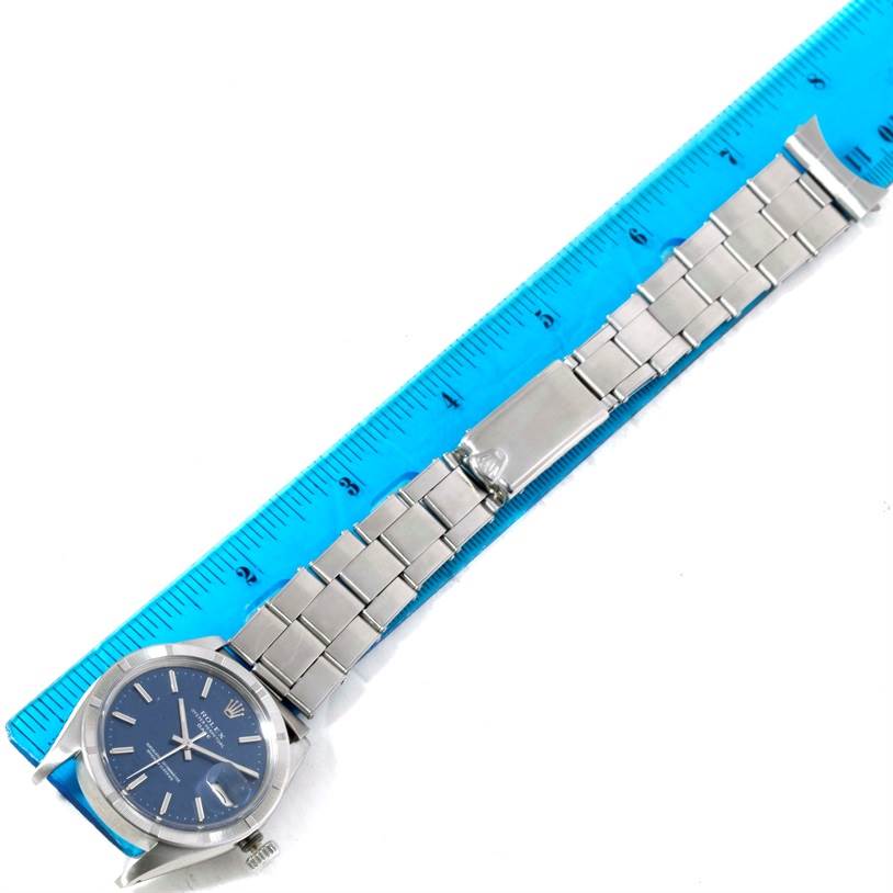 The image shows an overhead view of a Rolex Vintage Collection 1501 Men's Stainless Steel Blue Dial 1501 Men's Stainless Steel Blue Dial watch with a blue dial and a metal bracelet, placed alongside a ruler.