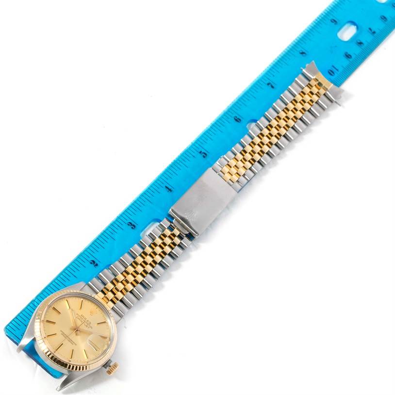 The image shows a Rolex Vintage Collection 16013 Men's Stainless Steel Champagne Dial 16013 Men's Stainless Steel Champagne Dial watch with a gold and silver band, placed next to a blue ruler for scale.