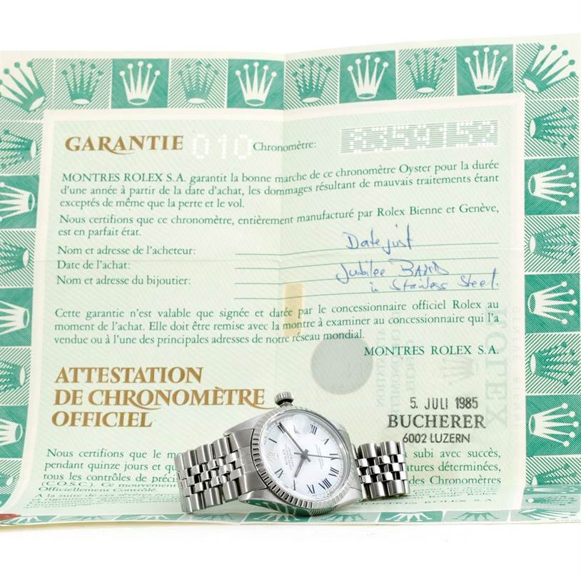 The image shows a Vintage Collection Rolex watch lying flat on a folded warranty certificate.