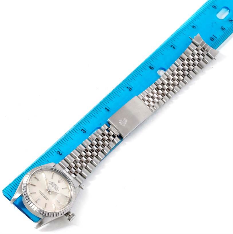 The image shows a Rolex Vintage Collection 16030 Men's Stainless Steel Silver Dial 16030 Men's Stainless Steel Silver Dial watch laid flat, with its face, bezel, and metal bracelet band visible, next to a blue ruler.