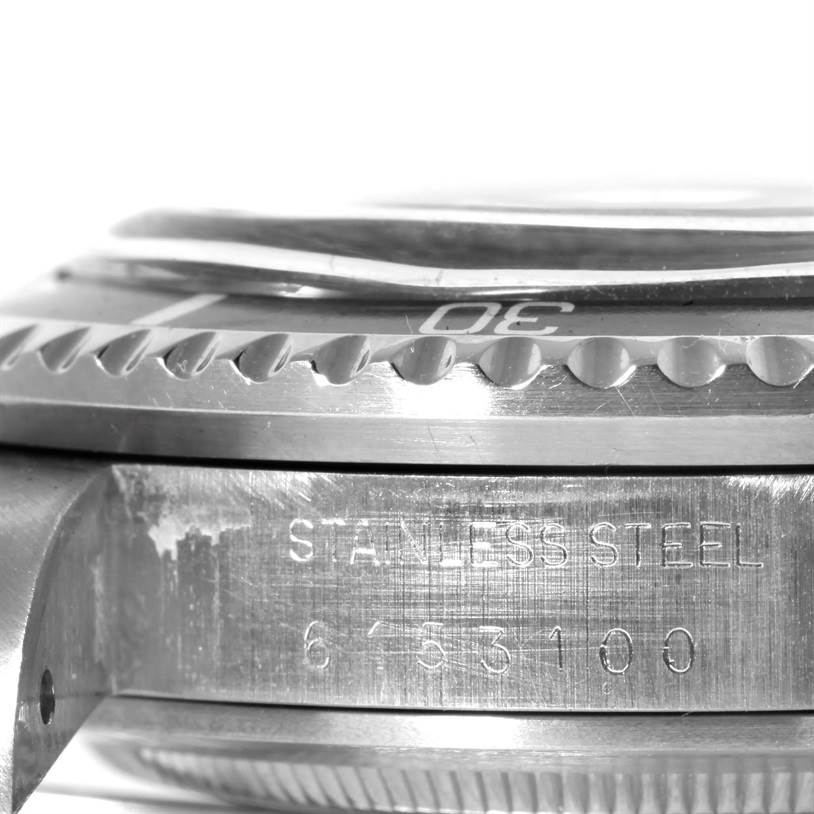 This image shows a close-up side view of the bezel and case of a Vintage Collection Rolex watch, with engraved text detailing.Serializable