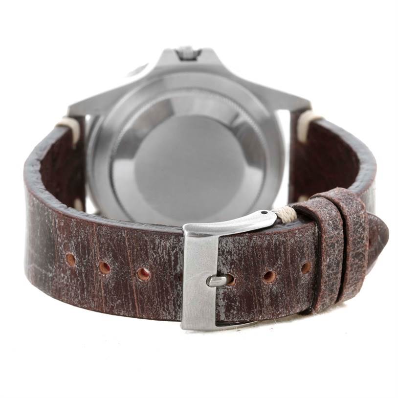 The image shows the back view of a Rolex Vintage Collection 1675 Men's Stainless Steel Black Dial 1675 Men's Stainless Steel Black Dial watch, highlighting the leather strap and metal buckle.