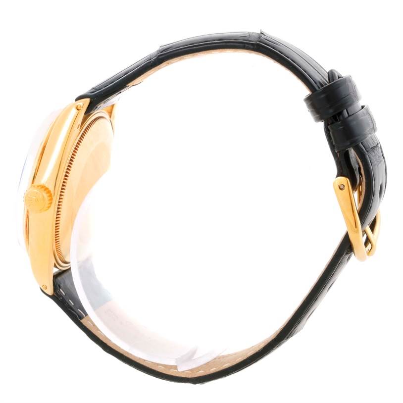 The image shows the side view of a Vintage Collection Rolex watch with a gold case and a black leather strap.