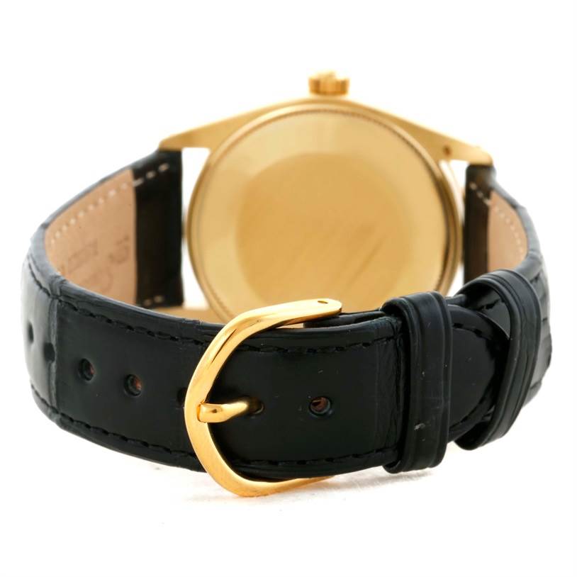 This image shows the back view of the Rolex Vintage Collection 1002 Men's Yellow Gold Champagne Dial 1002 Men's Yellow Gold Champagne Dial watch, highlighting its gold case and black leather strap with a gold buckle.