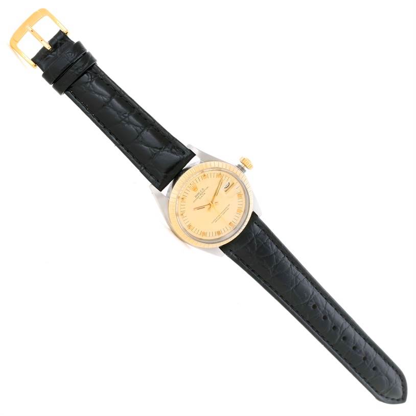 The watch, a Rolex Vintage Collection 1505 Men's Yellow Gold Champagne Dial 1505 Men's Yellow Gold Champagne Dial model, is shown in a top-down view featuring its black strap, gold bezel, and dial.