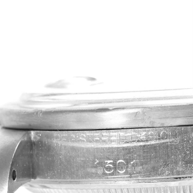 This image shows a close-up side view of the casing and bezel of a Vintage Collection Rolex watch, featuring engraved details.