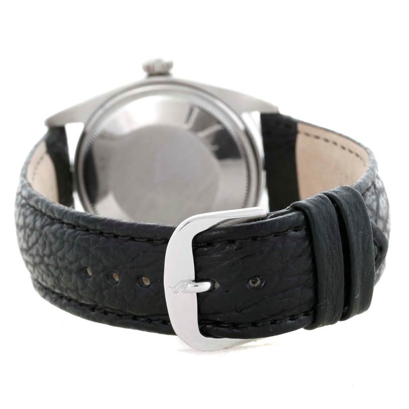 The image shows the backside of the Rolex Vintage Collection 1501 Men's Stainless Steel Silver Dial 1501 Men's Stainless Steel Silver Dial watch and the leather strap with a buckle.