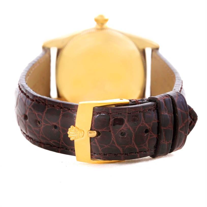 The image shows the back of a Vintage Collection Rolex watch, highlighting its brown leather strap and gold clasp.