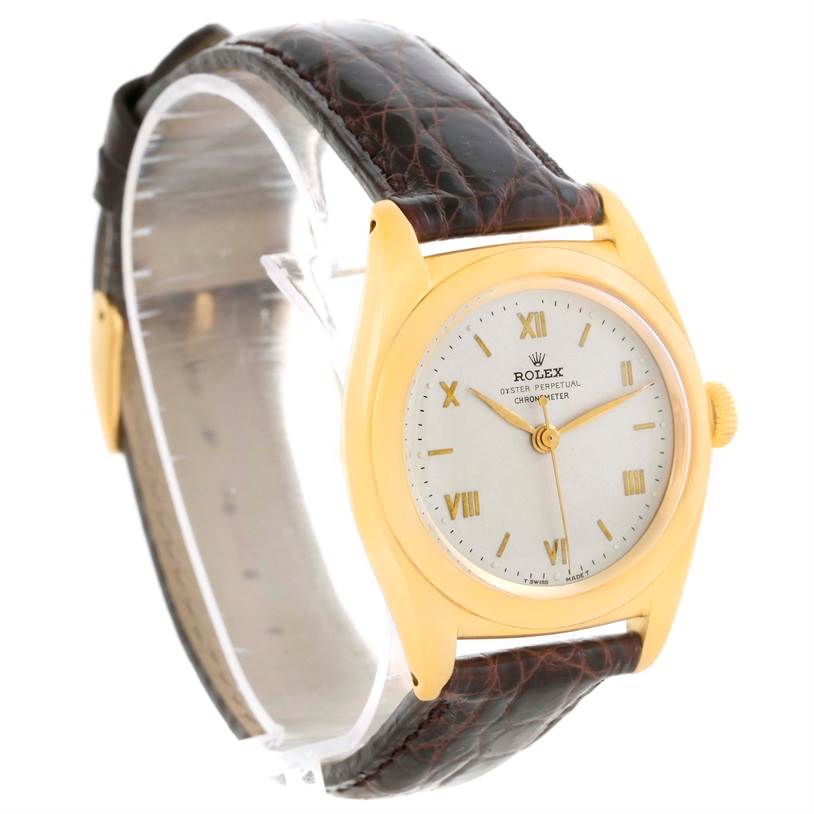 This image shows a side angle of the Rolex Vintage Collection 3131G Men's Yellow Gold Silver Dial 3131G Men's Yellow Gold Silver Dial watch featuring a gold case, white dial, and brown leather strap.
