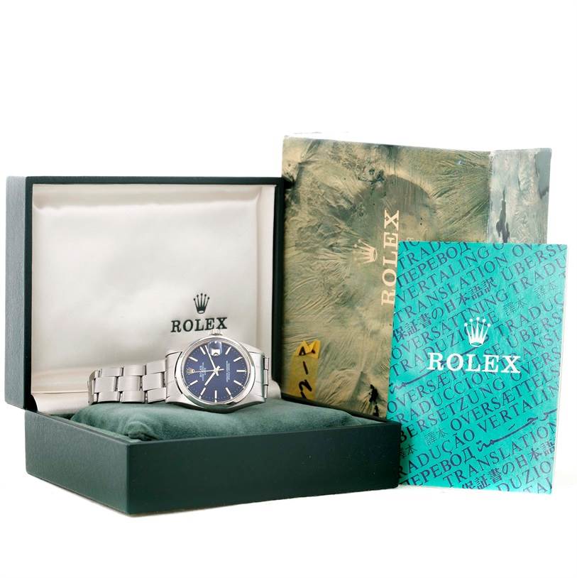 The image shows a Rolex Vintage Collection 1500 Men's Stainless Steel Blue Dial 1500 Men's Stainless Steel Blue Dial watch with its box, a green pouch, and documentation, viewed from an angle slightly above and to the side.