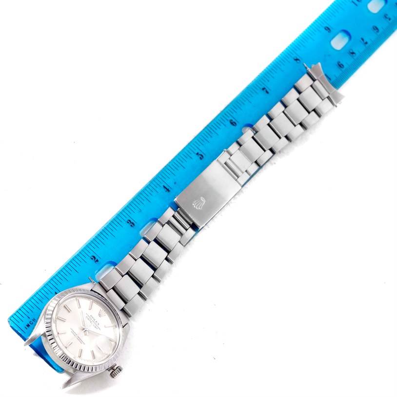 This image shows the Vintage Collection Rolex watch laid flat next to a blue ruler, highlighting its full bracelet and clasp.