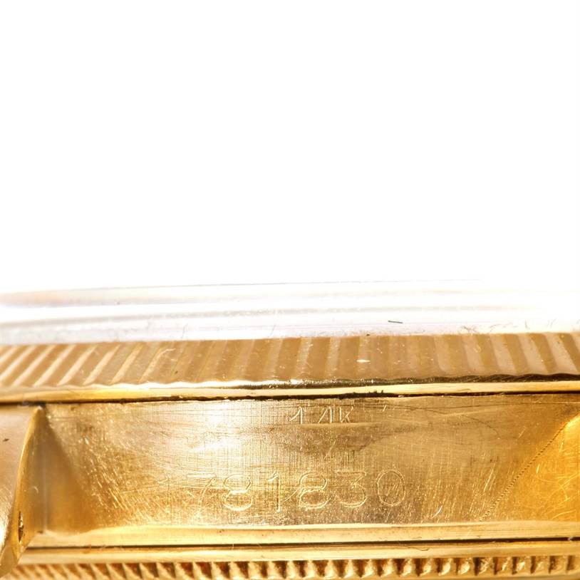 The image shows a close-up of the side of a Rolex Vintage Collection 1503 Men's Yellow Gold Silver Dial 1503 Men's Yellow Gold Silver Dial model, focusing on the serial number and the fluted bezel.