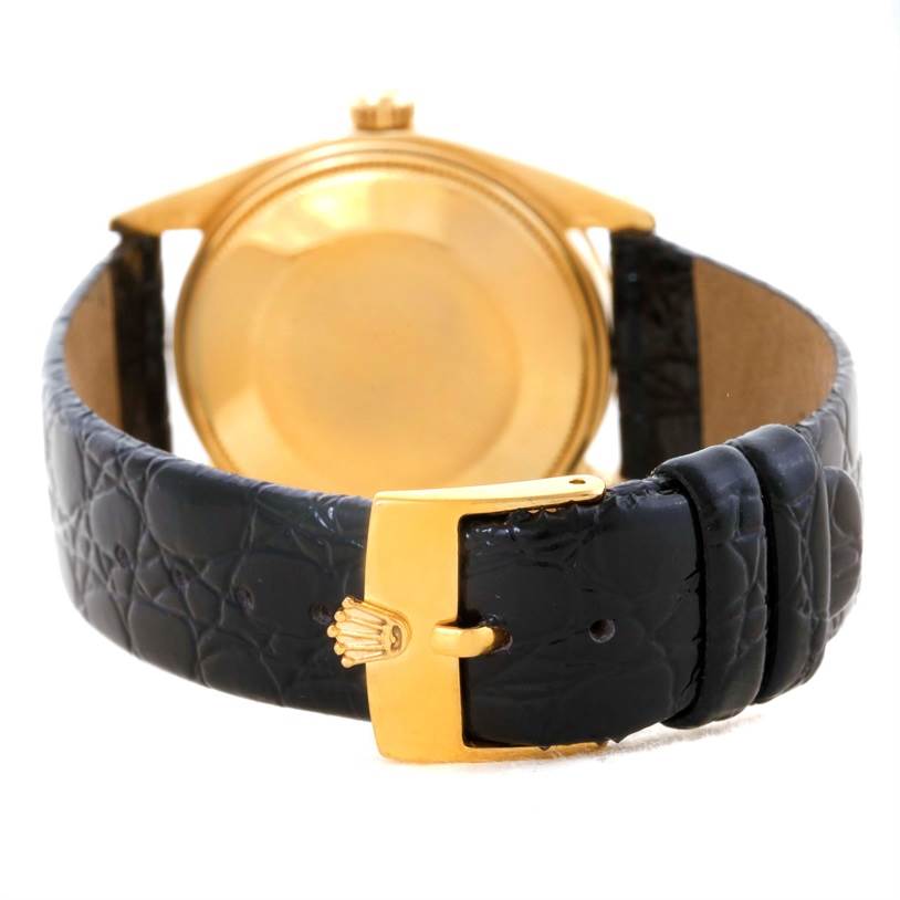 The image shows the back of a Rolex Vintage Collection 1503 Men's Yellow Gold Silver Dial 1503 Men's Yellow Gold Silver Dial watch, highlighting the case back and black leather strap with a gold buckle.