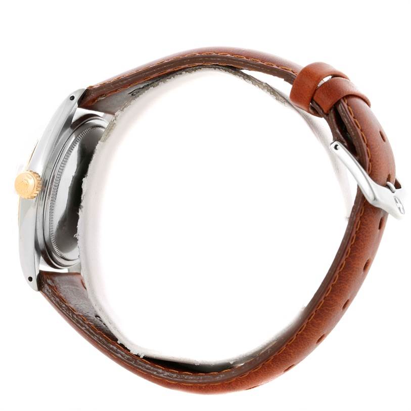 The image shows a side view of a Rolex Vintage Collection 1601 Men's Stainless Steel Silver Dial 1601 Men's Stainless Steel Silver Dial watch, highlighting its crown, casing, and brown leather strap with a buckle.