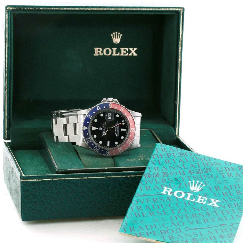 The Rolex Vintage Collection 16750 Men's Stainless Steel Black Dial 16750 Men's Stainless Steel Black Dial watch is shown inside its open box, along with a teal-colored instruction manual.