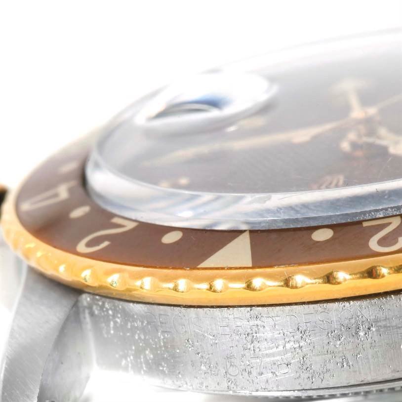The image shows a close-up side angle of the bezel, crystal, and part of the case of a Rolex Vintage Collection 1675 Men
s Stainless Steel Brown Dial 1675 Men
s Stainless Steel Brown Dial watch.