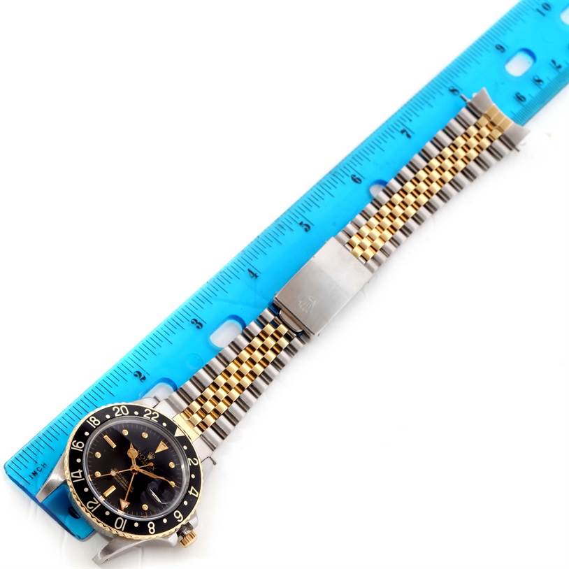 The image shows a Rolex Vintage Collection 16753 Men's Stainless Steel Black Dial 16753 Men's Stainless Steel Black Dial watch laid flat with the face, bezel, and band visible alongside a ruler.