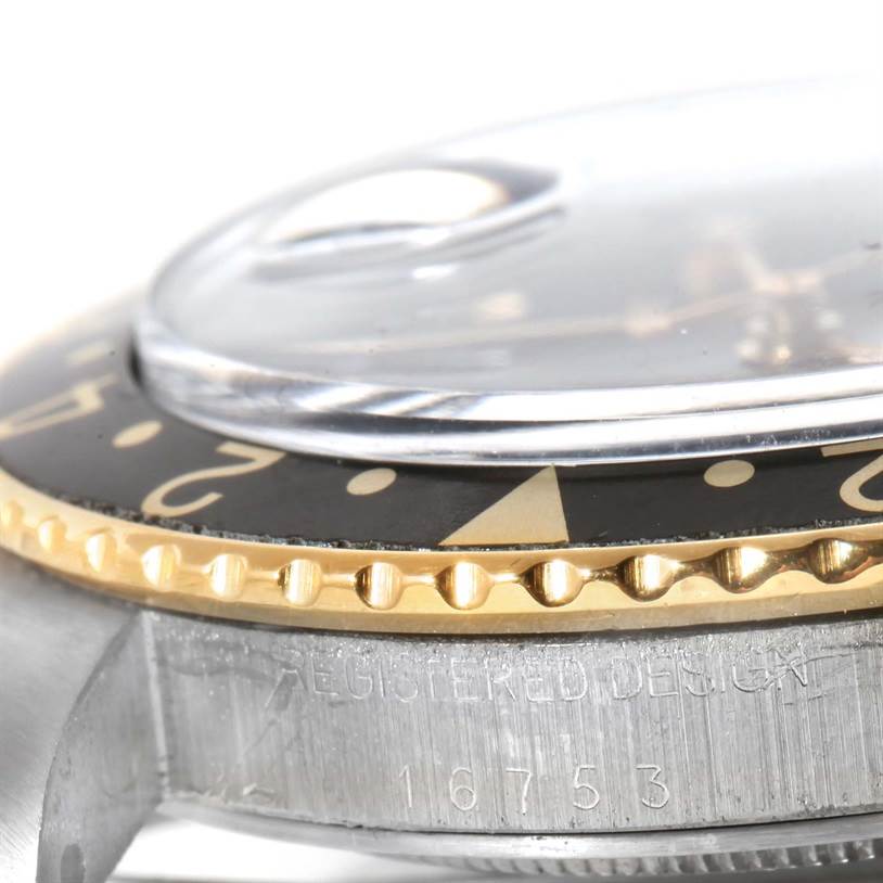 This close-up shows the edge of the bezel, crystal, and part of the case with engraved text of the Rolex Vintage Collection 16753 Men's Stainless Steel Black Dial 16753 Men's Stainless Steel Black Dial model.