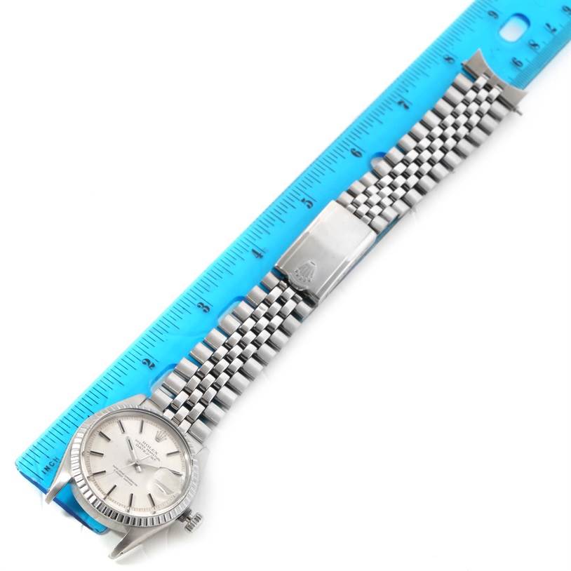 The Rolex Vintage Collection 1603 Men's Stainless Steel Silver Dial 1603 Men's Stainless Steel Silver Dial watch is shown from an angled top view with a blue ruler beside it, highlighting the bracelet and clasp.