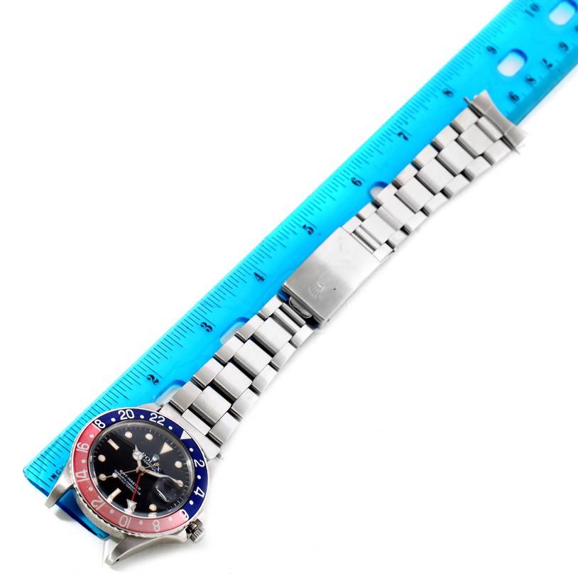 The image shows a top view of a Rolex Vintage Collection 16750 Men's Stainless Steel Black Dial 16750 Men's Stainless Steel Black Dial model watch with its bracelet measured against a blue ruler.