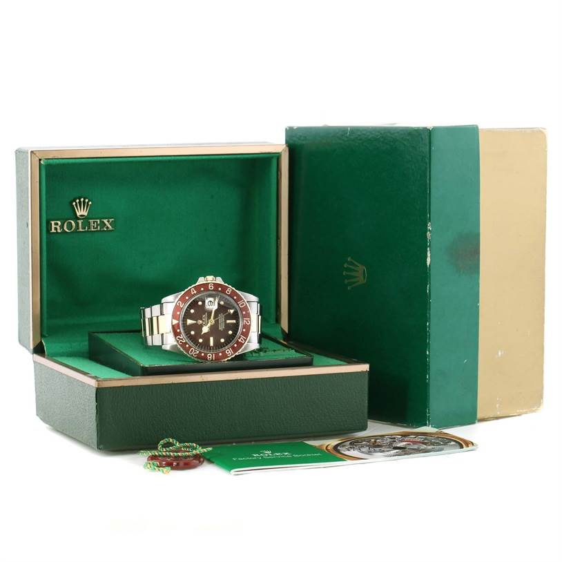 The image shows a Vintage Collection Rolex watch in its green box with additional accessories and papers displayed.