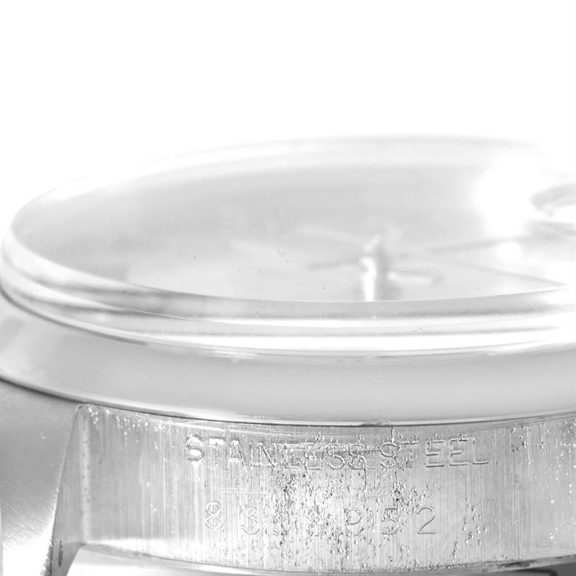 The image shows a partial side view of the case and crystal of a Rolex Vintage Collection 6694 Men's Stainless Steel Black Dial 6694 Men's Stainless Steel Black Dial model, highlighting the stainless steel material and etched details.