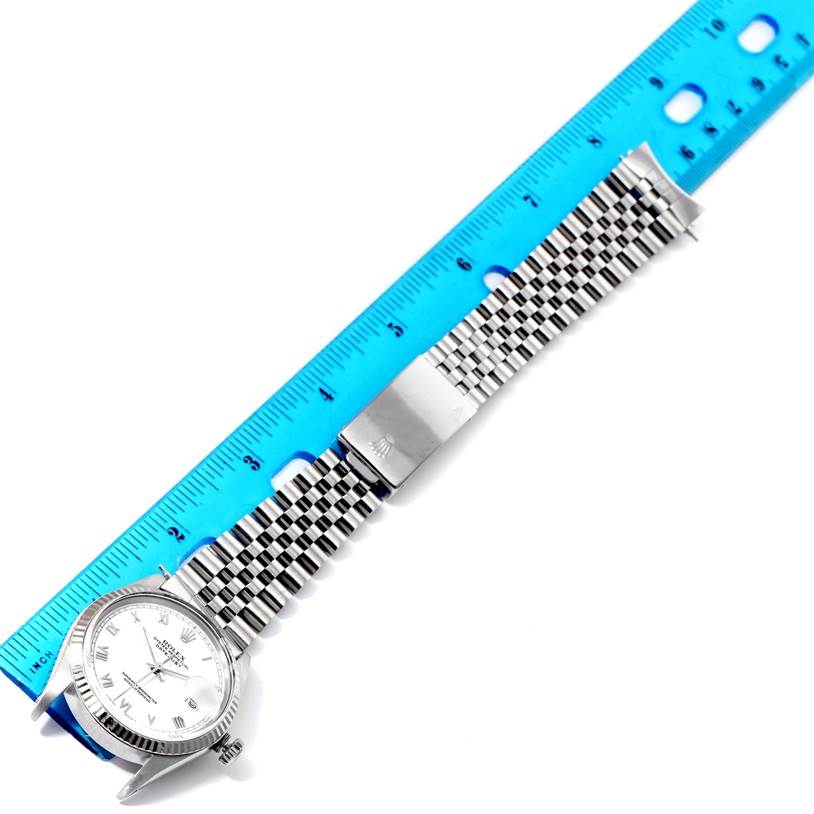 The image shows a top-down view of a Rolex Vintage Collection 16014 Men's Stainless Steel White Dial 16014 Men's Stainless Steel White Dial watch alongside a blue ruler, highlighting the face and stainless steel bracelet.